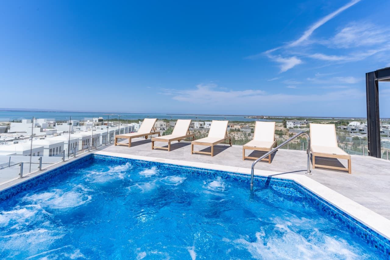 Jacuzzi en la azotea con camastros y vista a la bahía