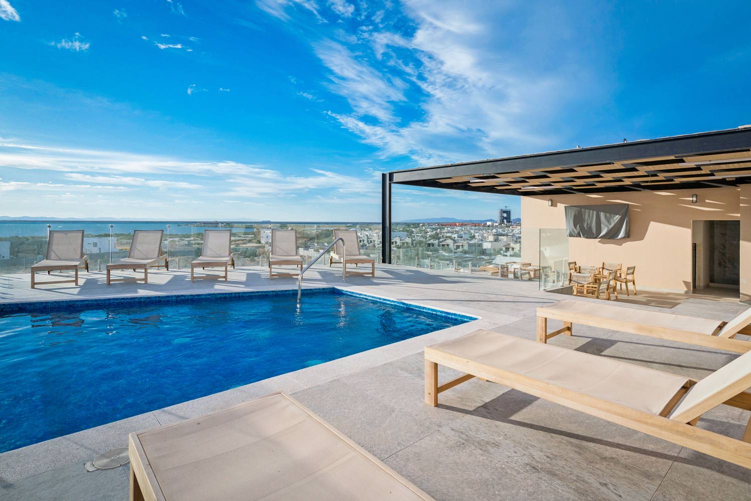 Terraza en la azotea con pérgola, camastros y vista a la bahía de La Paz